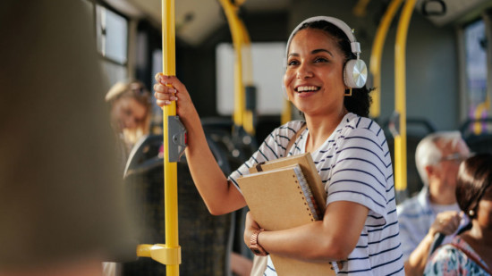 Mädchen mit Kopfhörern und Mappe im Bus